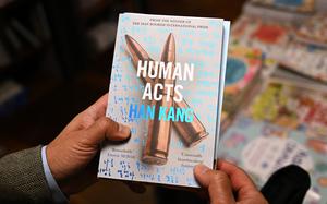 A man shows a book of South Korean author Han Kang at a bookstore in Seoul on Oct. 11, 2024, after she was announced as the laureate of the 2024 Nobel Prize in Literature. From the president to K-pop megastars BTS, South Korea erupted into celebration on Oct. 10, after "The Vegetarian" author Han Kang won the country's first Nobel Prize for literature. (Jung Yeon-Je/AFP via Getty Images/TNS)