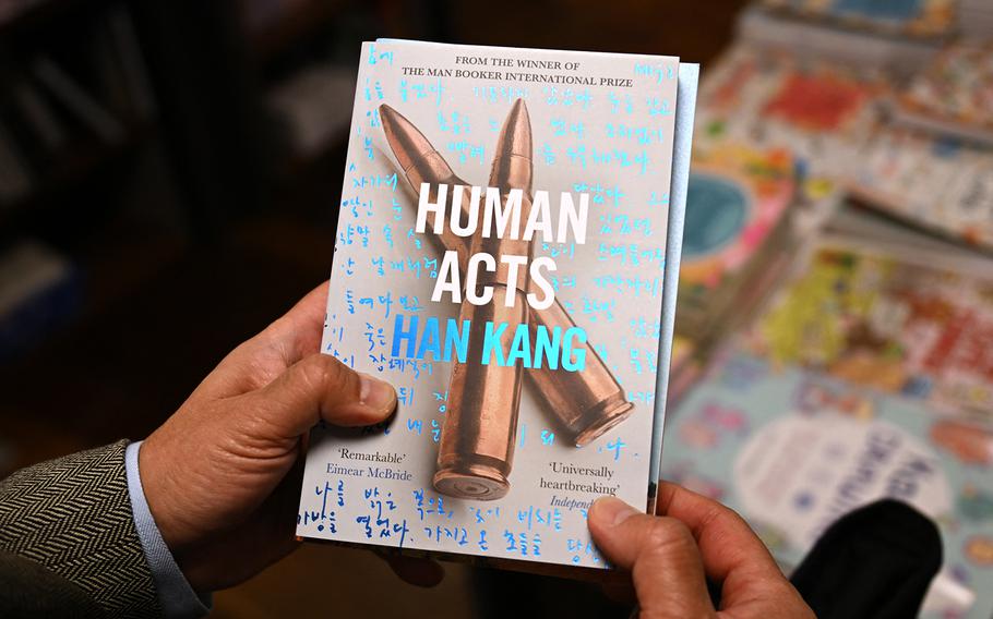 A man shows a book of South Korean author Han Kang at a bookstore in Seoul.