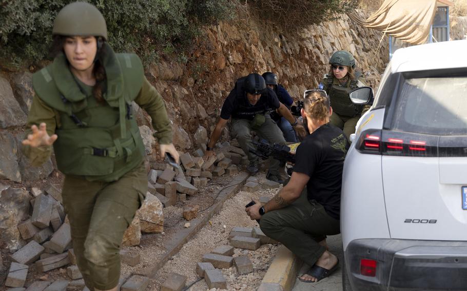 Israeli soldiers run for a cover