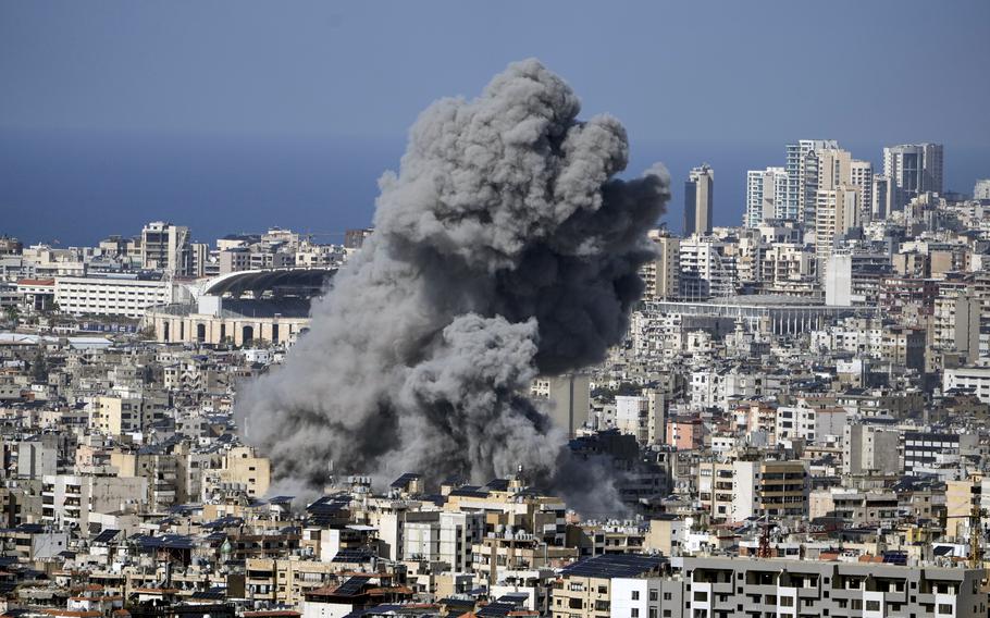 Smoke rises over a city skyline following an airstrike.