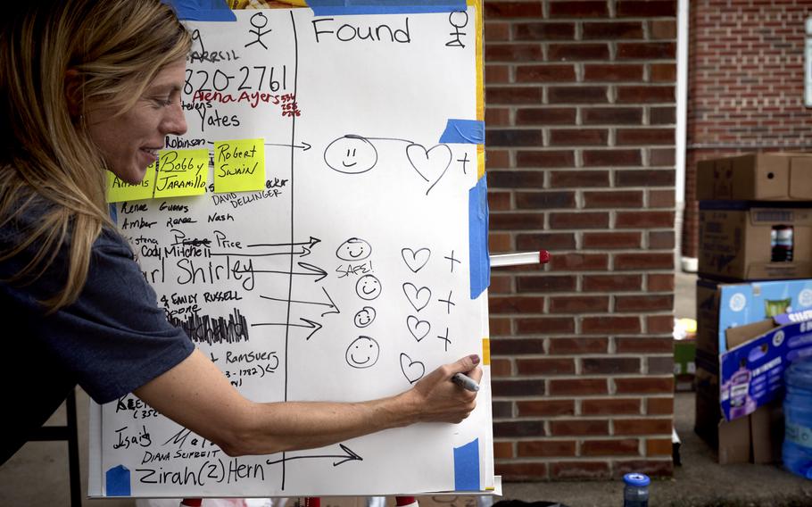 Melody Dowdy marks down the names of people missing and found.