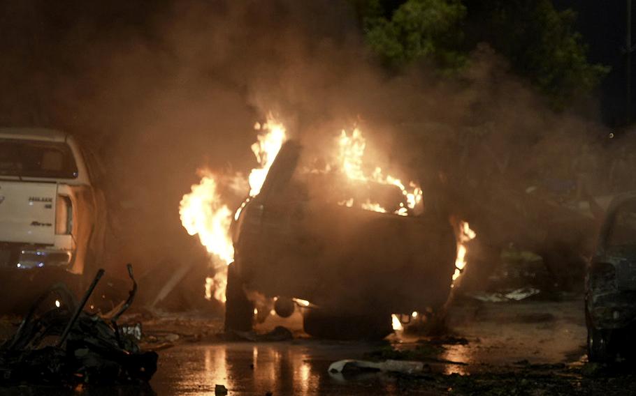 A vehicle is seen on fire at the site of an explosion outside the Karachi airport