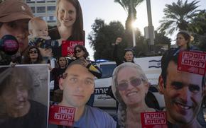 Protesters hold large cut-outs and photos of the images of hostages seized by Hamas.