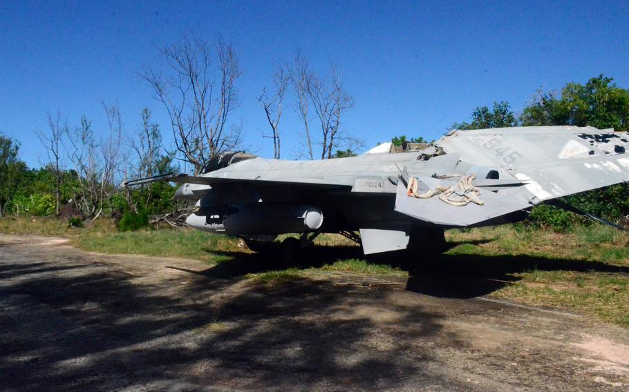 An F-16 Fighting Falcon aircraft is parked on the side of a path.