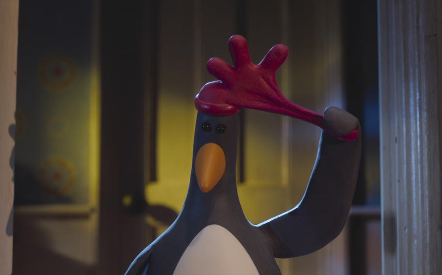 A stop-motion animation penguin pulls off the rubber glove that disguises him as a chicken. 