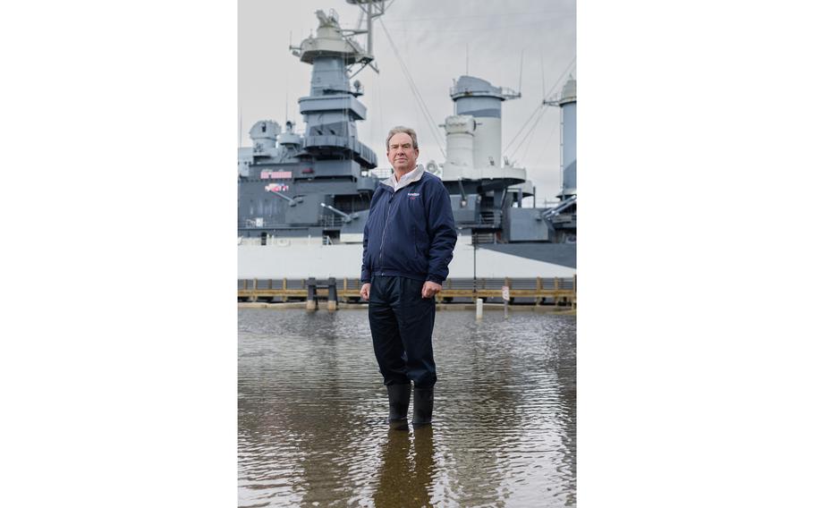 Retired U.S. Navy Capt. Terry Bragg, the executive director of the Battleship North Carolina museum, poses for a portrait in a flooded parking lot at the historic site in November 2023.