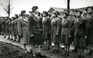 A black and white photo of the commander of the 6888th battilion inspecting her soldiers.