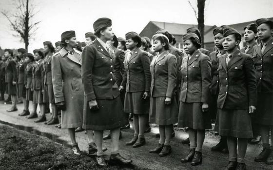 A black and white photo of the commander of the 6888th battilion inspecting her soldiers.