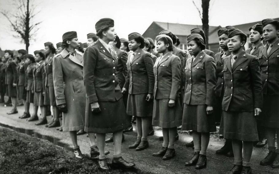 A black and white photo of the commander of the 6888th battilion inspecting her soldiers.