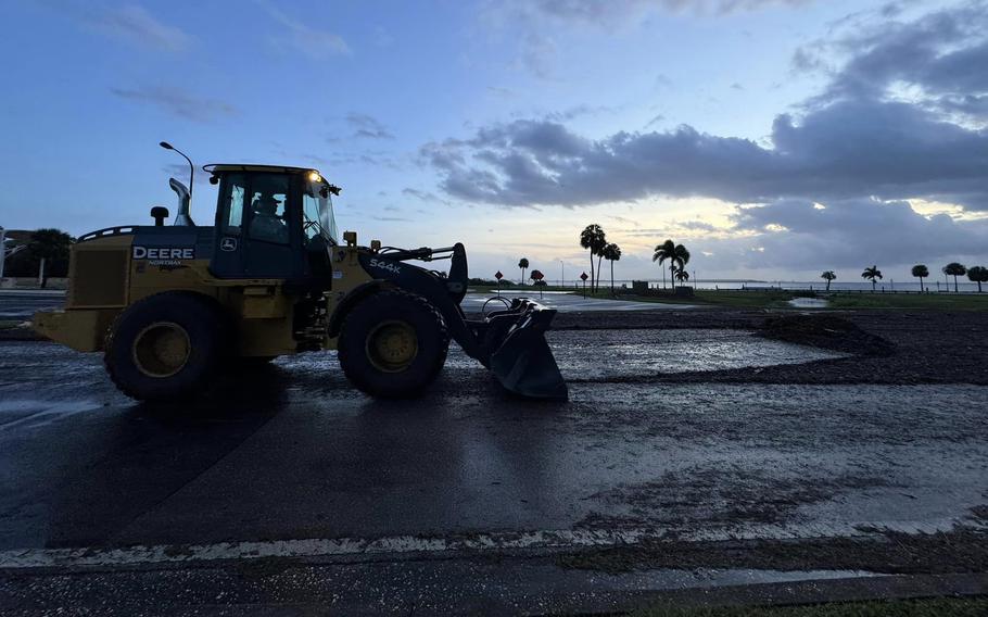 A bulldozer clears debris from a road.