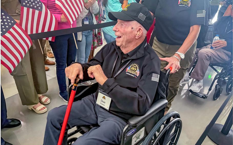 World War II veteran Don Graves smiles as he is cheered on Friday, May 31, 2024, before heading off to France for the 80th anniversary of the D-Day landings in Normandy. Graves fought as a Marine at Iwo Jima.