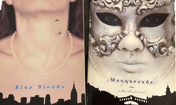 Two books, “Blue Bloods” and “Masquerade” by Melissa De La Cruz laying next to each other