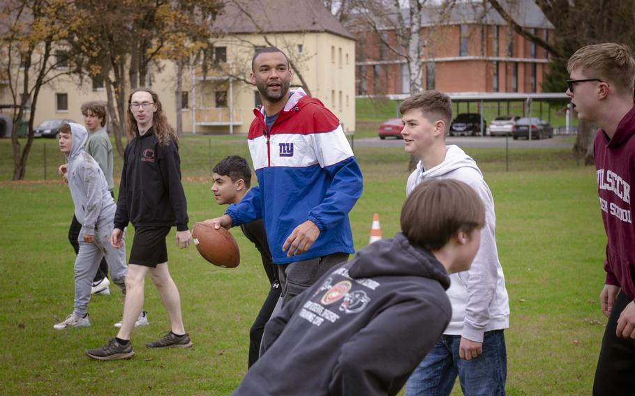 Brandon London, a former wide receiver for the New York Giants, plays football with students of Vilseck High School at Rose Barracks, Germany, Nov. 7, 2024. The visit along with fellow former Giant Victor Cruz precedes Sunday’s game against the Carolina Panthers in Munich.