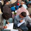 Afghan men and boys write during an English lesson at a military base in Germany.