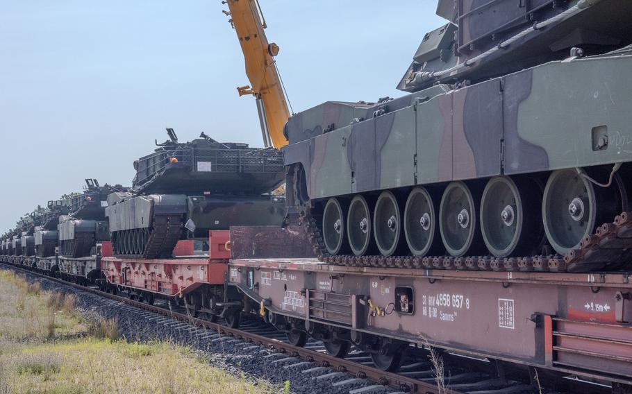 M1 Abrams tanks wait to be moved off a rail car to the staging area at the Powidz APS-2 Worksite in Powidz, Poland, on June 27, 2024. The newly arrived vehicles and equipment will serve as pre-positioned stock for armored brigades deploying to or training in Poland. 