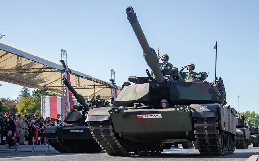Polish soldiers in M1 Abrams tanks salute officials during a parade in Warsaw, Poland, on Aug. 15, 2023. Poland was granted a second $2 billion loan from the U.S. for weapons acquisition. The previous loan went toward the purchase of Abrams tanks, F-35 Lightning II jets and other U.S. military hardware.