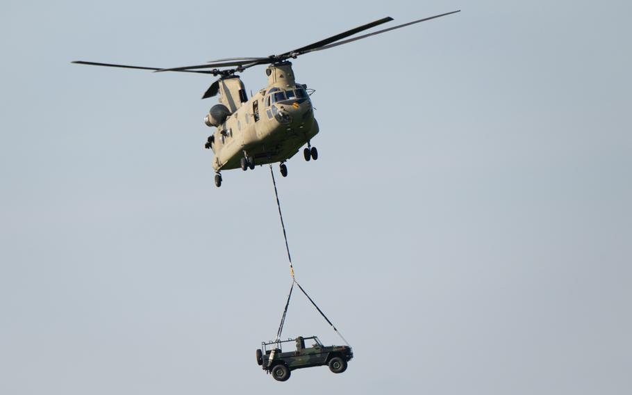 A Chinook aircraft delivers a Dutch military vehicle by sling load 