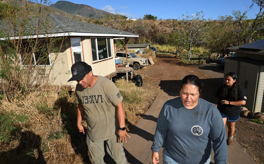 Daniel Kuulei Palakiko, Jaime Palakiko and their daughter Hi’ialo Palakiko walk through their family’s property.