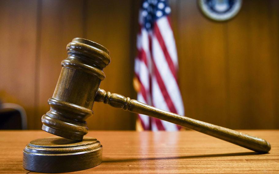 A gavel on a circular wooden stand.