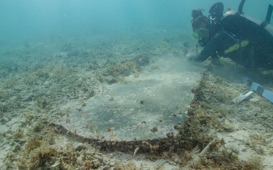 University of Miami graduate student Devon Fogarty examines the headstone of John Greer, who died while working at Fort Jefferson on Nov. 5, 1861. The gravesite is now completely underwater.