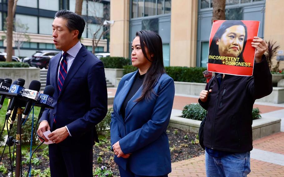 Former Oakland mayor Sheng Thao appears outside the Federal courthouse in Oakland, California, with her lawyer Jeff Tsai on Friday, Jan. 17, 2025, after being indicted on bribery and conspiracy charges by federal prosecutors. A protester stands behind Thao. (Ray Chavez/TNS)