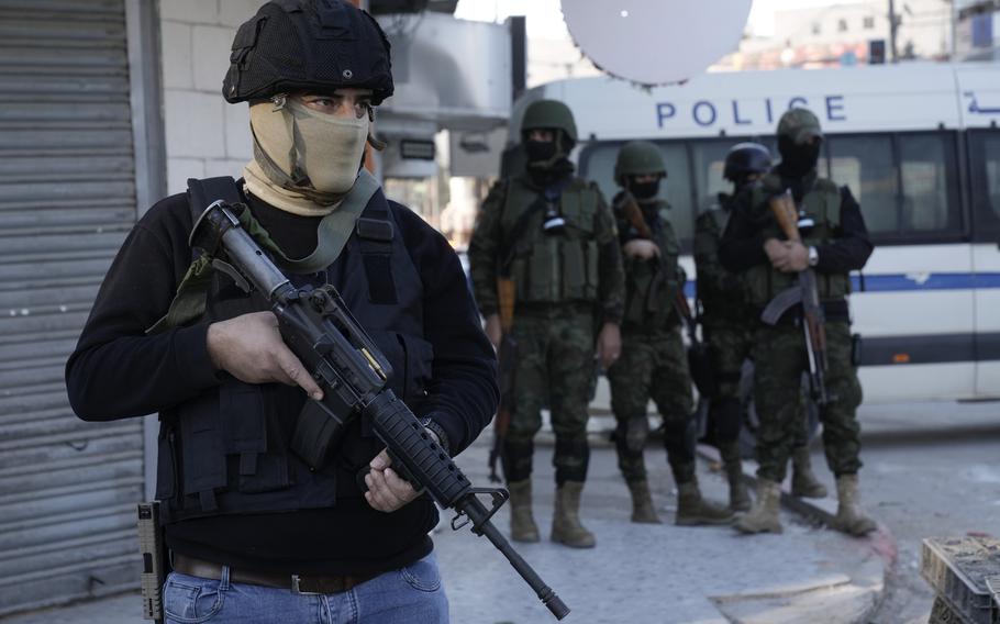 An officer from the Palestinian Authority clutches his gun