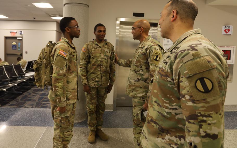 Gen. Gary Brito talks with two soldiers as Sgt. Maj. Raymond Harris looks on