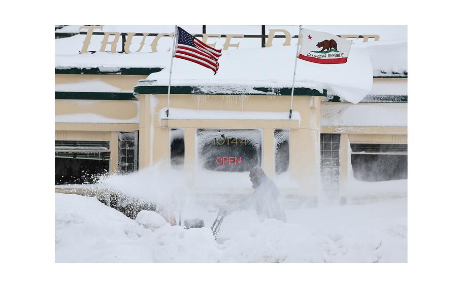 Valentino Perez uses a snowblower in front of a restaurant north of Lake Tahoe during a powerful multiple day winter storm in the Sierra Nevada mountains on Saturday, March 2, 2024, in Truckee, California. 