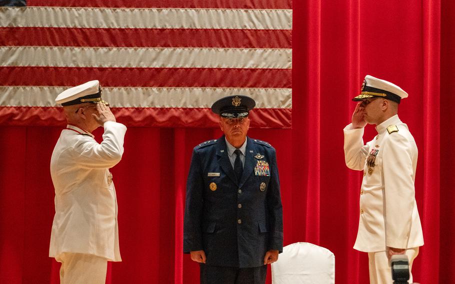 Rear Adm. Carl Lahti, left, and Rear Adm. Ian Johnson, right, salute in front of Lt. Gen. Ricky Rupp during a change of command ceremony for U.S. Naval Forces Japan and Navy Region Japan at Yokosuka Naval Base, Japan, June 26, 2024.