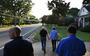 Accompanied by Secret Service even in tiny Plains, Ga., the Carters walk home after dinner at a friend's house in 2018. MUST CREDIT: Matt McClain/The Washington Post