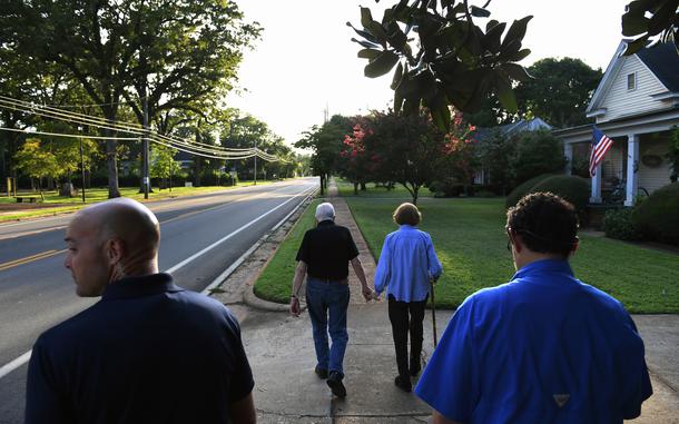 Accompanied by Secret Service even in tiny Plains, Ga., the Carters walk home after dinner at a friend's house in 2018. MUST CREDIT: Matt McClain/The Washington Post