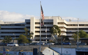 An American flag flies in front of the Department of Veterans Affairs campus building.