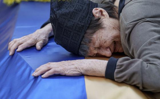 A mother cries near the coffin of her son killed in a Russian rocket attack at a Ukrainian military academy, during his funeral ceremony in Poltava, Ukraine, Saturday Sept. 7, 2024. (AP Photo/Evgeniy Maloletka)