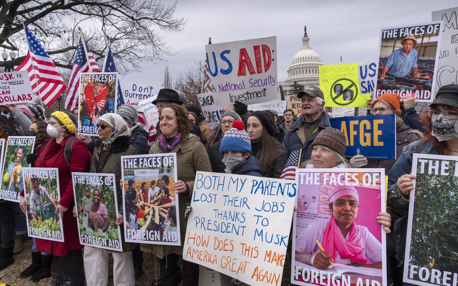 Demonstrators protest against cuts to USAID in front of the U.S. Capitol building.