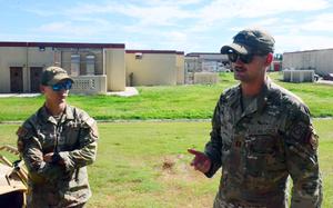 Air Force airmen stand outside instructing a course.