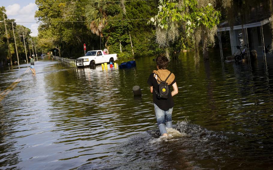 Residents walk through a flooded street after Hurricane Idalia made landfall in Cristal River, Fla., on Wednesday, Aug. 30, 2023.