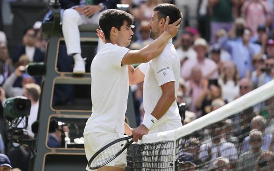 Carlos Alcaraz, left, of Spain is congratulated by Novak Djokovic of Serbia after winning the men's singles final at the Wimbledon tennis championships in London, Sunday, July 14, 2024. (AP Photo/Kirsty Wigglesworth)