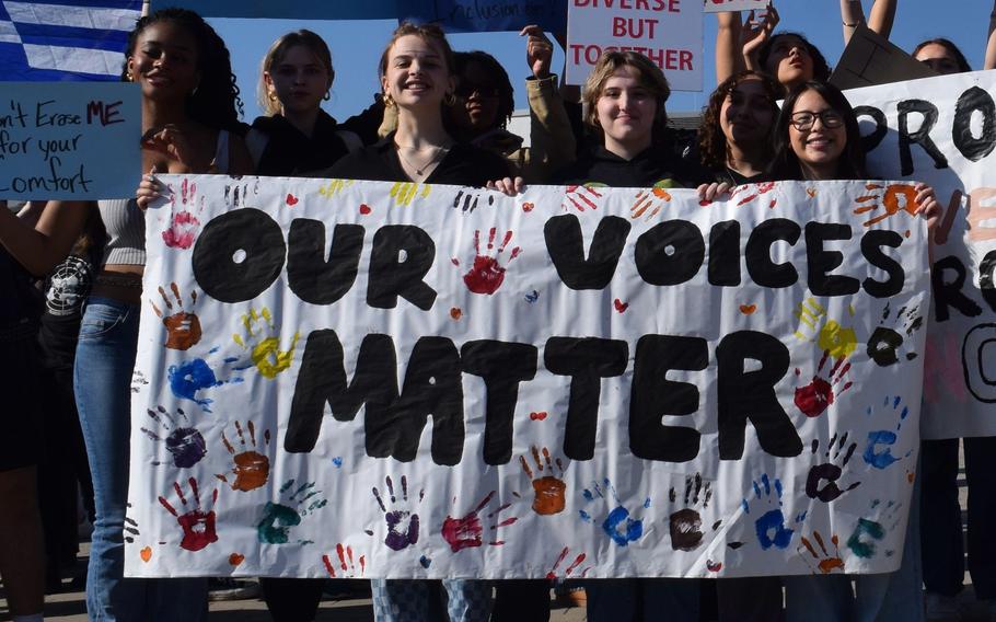 Students hold up protest signs