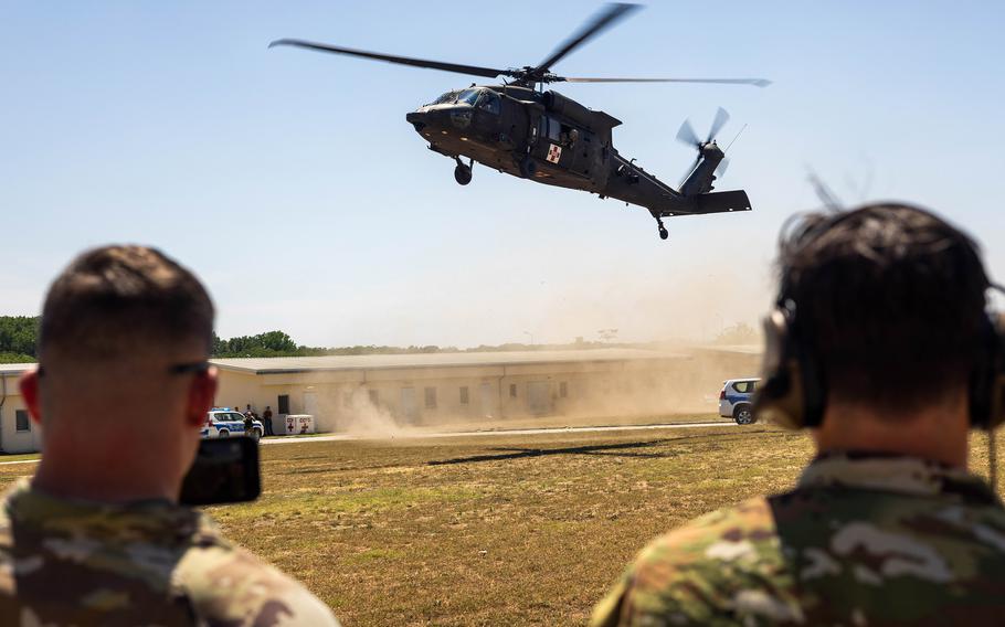 Soldații americani urmăresc un elicopter Black Hawk care aterizează pentru pregătire medicală la Baza Aeriană Mihail Kogălniceanu din România, 11 iulie 2024. Corpul Inginerilor Armatei SUA a declarat că o nouă platformă de marfă la bază va susține avioane rotative și cu aripi fixe.