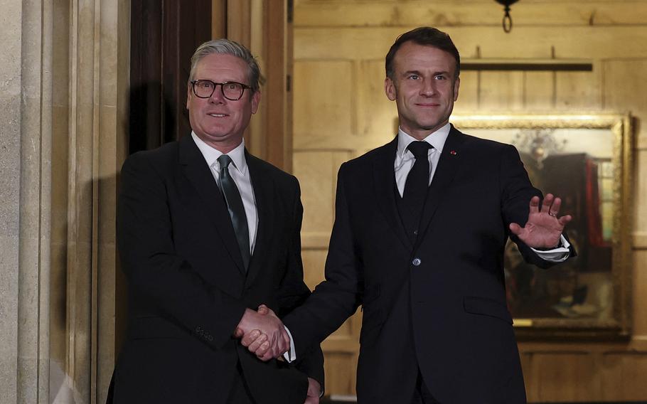 British Prime Minister Keir Starmer, left, and French President Emmanuel Macron shake hands.