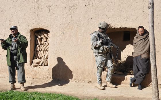 Pashtun Zarghun district, Afghanistan, Feb. 9, 2010: Afghan Police Capt. Abdul Zaher, left, and Staff Sgt. Darvin Cosby, 29, of Chicago, center, guard a suspect arrested by Afghan police as they search his home for bomb-making materials. A small homemade bomb partially exploded near a joint U.S. and Afghan police convoy earlier in the day, causing no injuries. The device exploded just alongside the village of Dastha Bam in the Pashtun Zarghun district of Herat province.

Read the 2010 article and see additional photos here.https://www.stripes.com/theaters/middle_east/laying-down-the-law-in-herat-1.99113

META DATA: Operation Enduring Freedom; Wars on Terror; Afghanistan; Taliban; U.S. Army; 82nd Airborne, 4th Squadron, 73rd Cavalry Regiment; 