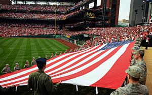 Airmen from the 375th Air Mobility Wing at Scott Air Force Base, Ill., present a giant American flag at Busch Stadium in St. Louis in 2013. Service members can once again unfurl the U.S. flag horizontally at sporting events and ceremonies, according to the Defense Department, which issued a memo Jan. 10, 2025, undoing its ban from nearly two years earlier.