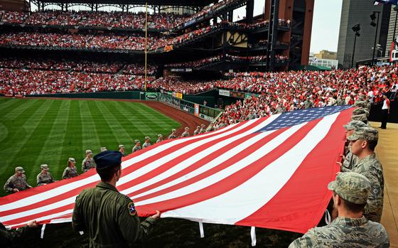 Airmen from the 375th Air Mobility Wing at Scott Air Force Base, Ill., present a giant American flag at Busch Stadium in St. Louis in 2013. Service members can once again unfurl the U.S. flag horizontally at sporting events and ceremonies, according to the Defense Department, which issued a memo Jan. 10, 2025, undoing its ban from nearly two years earlier.