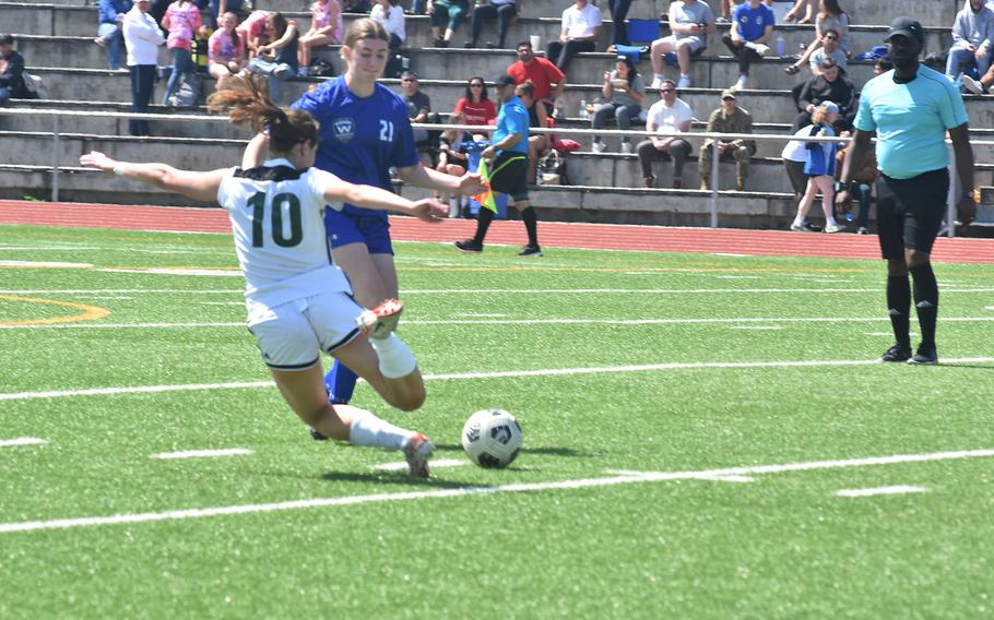 SHAPE's Flavia Taveri goes to the ground to try to maintain possession as Wiesbaden's Nora Hygh closes in Monday, May 20, 2024, on the opening day of the DODEA European Division I girls soccer championships at Ramstein High School.