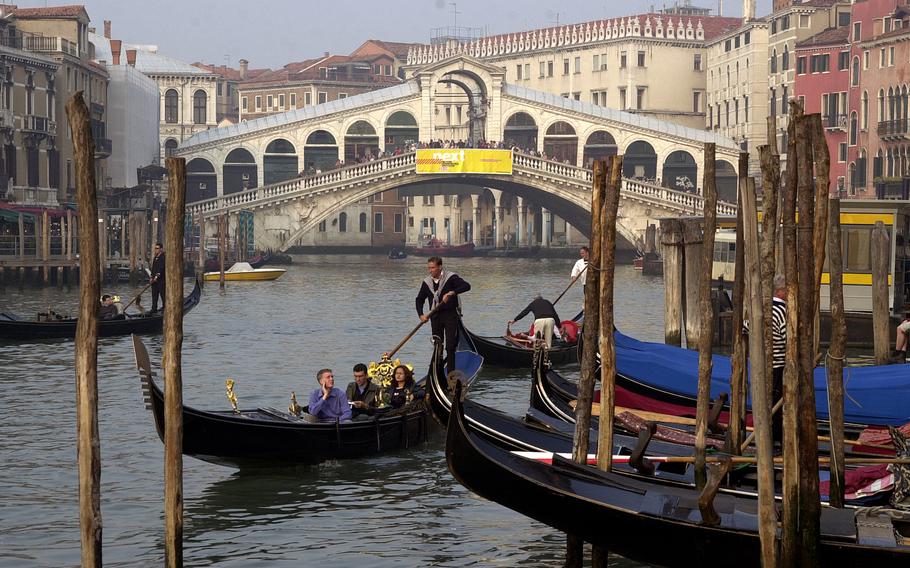 A gondola plies the Grand Canal in Venice, Italy. The city is charging day-trippers a 5-euro tax on certain days in an effort to limit tourism, but U.S. military families stationed in Vicenza can request an exemption.