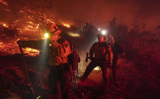 Firefighters battle the Lilac Fire in Bonsall, Calif., Tuesday, Jan. 21, 2025. (AP Photo/Jae C. Hong)