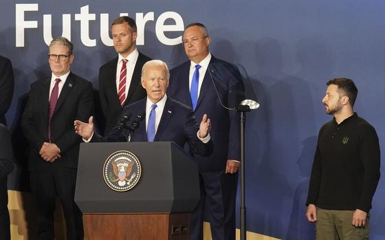 Britain's Prime Minister Sir Keir Starmer, left, and Ukrainian President Volodymyr Zelenskyy, right, look on as U.S. President Joe Biden speaks during an event on the Ukraine Compact at the NATO Summit at the Walter E. Washington Convention Center, in Washington, Thursday, July 11, 2024. Biden launched the Ukraine Compact, signed by 25 countries and the European Union, as part of a commitment to Ukraine's long term security. 