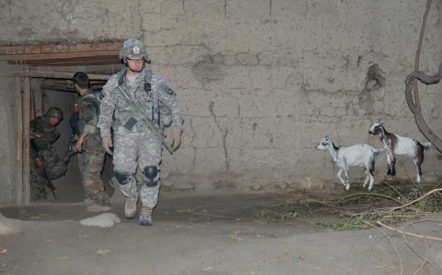 Lt. Col Joe Ryan, commander of the 1st Battalion, 327th Infantry Regiment, emerges from a compound where Afghan and U.S. forces searched for insurgent weapons during a dawn raid in the hostile Chinar village of Pech River Valley on July 21, 2010.