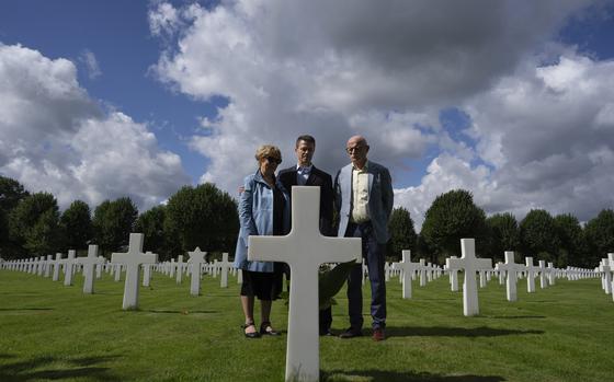 Eighty years after the liberation of the south of the Netherlands, Scott Taylor, center, Ton Hermes and Maria Kleijnen stand next to the grave of Scott's grandfather Second Lt. Royce Taylor, a bombardier with the 527 Bomb Squadron, at the Netherlands American Cemetery in Margraten, southern Netherlands, on Wednesday, Sept. 11, 2024.