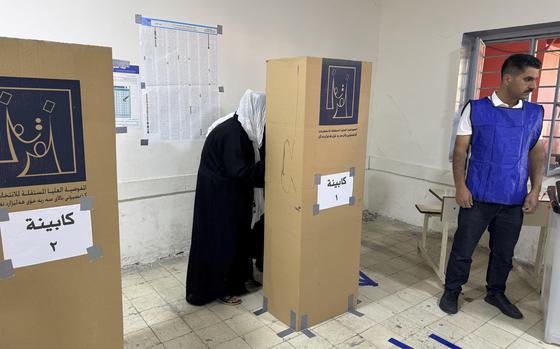 A woman enters a voting boot during parliamentary elections of Iraq’s semi-autonomous northern Kurdish region, in Irbil, Sunday, Oct. 20, 2024. (AP Photo/Salar Salim)